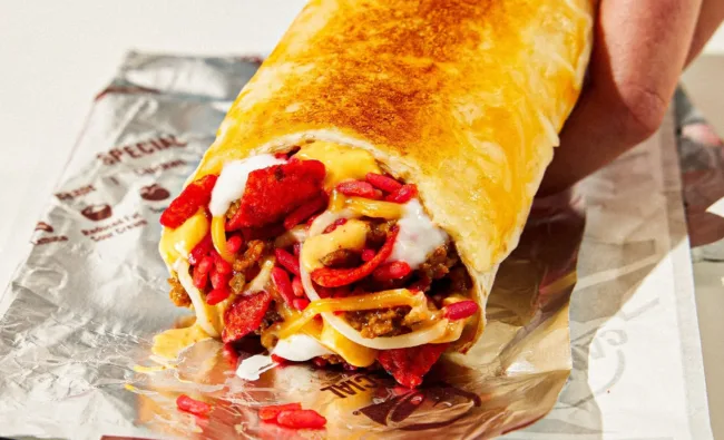 Taco Bell’s Flamin’ Hot Grilled Cheese Burrito, featuring the brand-new Flamin’ Hot Rice, Fritos Flamin’ Hot chips, seasoned beef, creamy sauces, and a grilled cheese crust.
