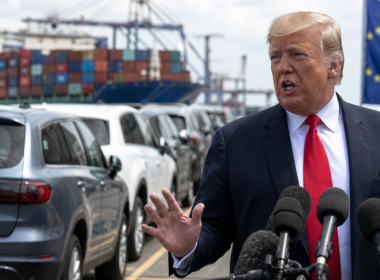 Representative image of United States President Donald Trump addressing reporters as imported cars and shipping containers frame the renewed United States–European Union auto tariff dispute, after Washington threatened to raise tariffs on European Union cars and trucks to 25 per cent.
