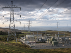 Representative image of electricity transmission infrastructure, a modern power substation and wind turbines, illustrating SSE plc’s £33 billion investment plan to expand UK energy networks and support long-term grid growth after its FY2026 preliminary results.