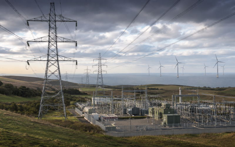 Representative image of electricity transmission infrastructure, a modern power substation and wind turbines, illustrating SSE plc’s £33 billion investment plan to expand UK energy networks and support long-term grid growth after its FY2026 preliminary results.