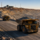 Autonomous mining trucks move through a large open-pit mine, illustrating how software-controlled haulage is reshaping mining economics, fleet productivity and the shift toward battery-electric operations. Representative image.